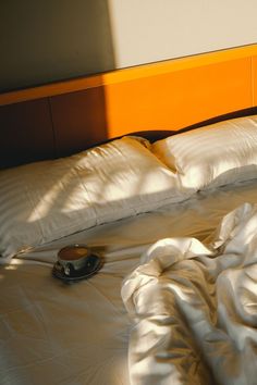 an unmade bed with white sheets and pillows