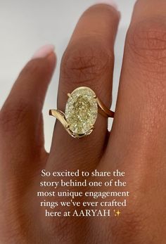 a close up of a person's hand with a yellow diamond ring on it