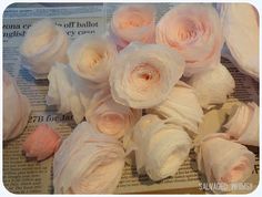 some white flowers on top of a newspaper