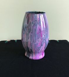 a purple vase sitting on top of a black table