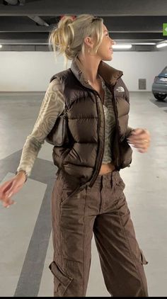 Puffer Vest Outfits For Women Streetwear, Buff Vest Outfit, Sleeveless Puffer Jacket Outfits Women, Cargo Pants And Puffer Vest, Puffy Vest Outfit Street Style, Sleeveless Puffer Vest Outfit, Sleeveless Puffer Outfit, Buffer Vest Outfit, Brown Puffy Vest Outfit