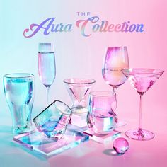 there are many different colored glasses on the table and in front of it is an advertisement for aura collection