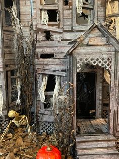 an old wooden house with a pumpkin in the front yard