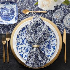 a blue and white place setting with gold trim