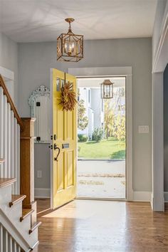 an open door leading to a front porch with stairs and light fixture hanging from the ceiling