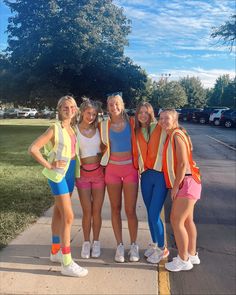 the girls are posing together on the sidewalk