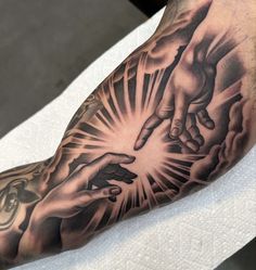 a man's arm with tattoos on it and two hands in the middle of his arm