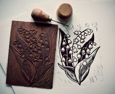 a rubber stamp with lily of the valley on it next to a wood block and ink pen