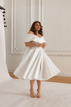 a woman in a white dress posing for the camera