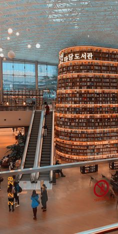 an escalator with many books stacked on top of it in a large building