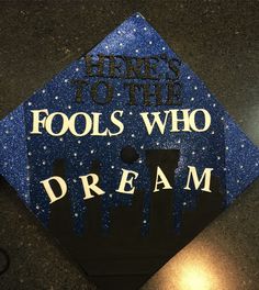 a blue graduation cap that says, here is to the fools who dream on it