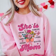 a woman wearing a pink sweatshirt with flowers on it