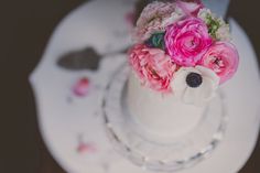 a small white cake with pink flowers on top