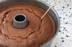 a chocolate cake in a pan with a wooden stick sticking out of the top one