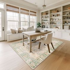 a dining room table with two chairs in front of it and built - in bookshelves