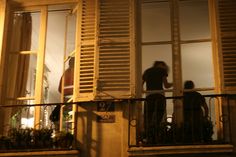 two people standing on a balcony at night