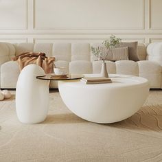 a living room filled with white couches and tables on top of carpeted flooring