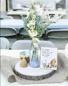 there is a vase with flowers in it and a card on the table next to it