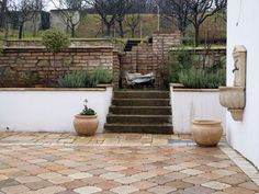 two large planters sitting on the side of a stone wall next to some steps