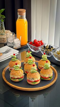 small sandwiches with cucumbers and tomatoes are arranged on a platter