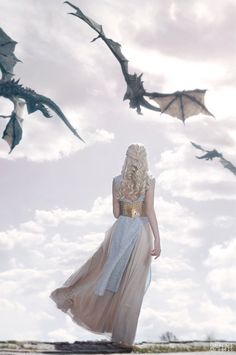 a woman in a long dress is flying bats