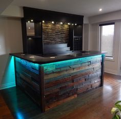 an empty bar with lights on it in the middle of a living room and wood flooring