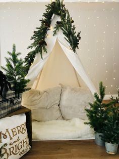 a teepee tent is decorated with christmas greenery