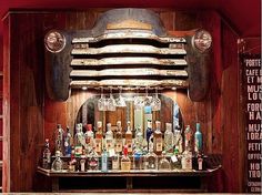 an old fashioned bar with lots of liquor bottles on the top and below it,