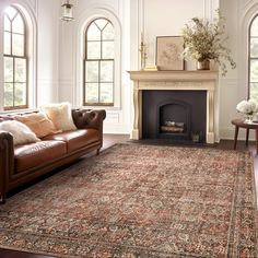 a living room filled with furniture and a fire place in front of a fireplace covered in windows