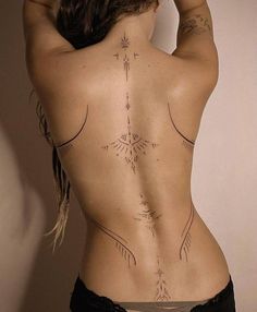 the back of a woman with tattoos on her body