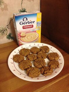 some cookies on a plate next to a box of gerber oatmeal