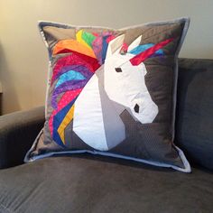 a pillow with a unicorn on it sitting on a couch