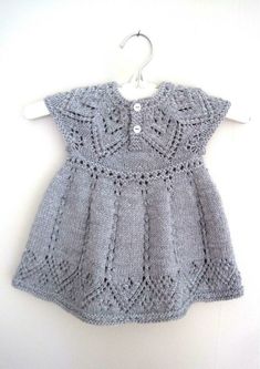 a gray knitted dress hanging on a white wall