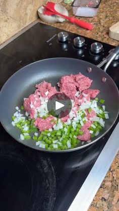 a frying pan filled with diced meat and onions on top of a stove