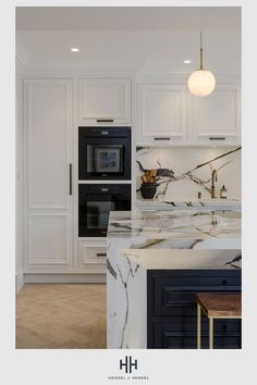 a kitchen with marble counter tops and black appliances in the center, along with white cabinets