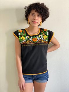 "Vibrant floral embroidered black Mexican top, ethnic boho hippie top, EXTRA SMALL Mexico blouse women, yellow orange white flowers, Puebla This Vibrant floral embroidered black Mexican top is an exceptional piece of clothing that showcases the beauty of traditional Mexican embroidery. The top features an exquisite multicolor floral embroidery in hues of yellow, orange, and white that creates a stunning contrast against the black base. The flowers are intricately sewn, giving the top an eye-catc Fitted Black Embroidered Top For Summer, Black Embroidered Summer Blouse, Fitted Folk Style Embroidered Top, Fitted Black Embroidered Top For Festival, Orange Bohemian Top With Floral Embroidery, Casual Orange Embroidered Blouse, Black Embroidered Top For Summer Festival, Orange Bohemian Cotton Top, Summer Embroidered Orange Blouse