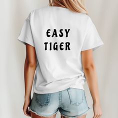 Easy Tiger T-Shirt, Graphic T-Shirt, Animal Gift Idea, Tiger Graphic T-Shirt, Vintage Inspired Shirt, Trendy Tiger T-Shirt , Boho Clothes Unleash your inner cool with our "Easy Tiger"  unisex t-shirt. Perfect for those who blend laid-back vibes with a hint of wild spirit, this tee is a stylish and comfortable addition to any wardrobe. Whether you're out on an adventure or just chilling at home, this shirt will keep you feeling and looking effortlessly cool. Hand-crafted designs by WildDayDreamer Trendy T-shirt With Funny Text For Everyday, Trendy Everyday T-shirt With Funny Text, Casual Funny Text Crew Neck T-shirt, Casual Crew Neck T-shirt With Funny Text, Basic Tops With Funny Text And Relaxed Fit, Basic Tops With Funny Text In Relaxed Fit, Trendy Funny Text T-shirt For Everyday, Basic Relaxed Fit Tops With Funny Text, Relaxed Fit Basic Tops With Funny Text