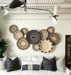 a living room filled with white furniture and lots of plates hanging on the wall above it