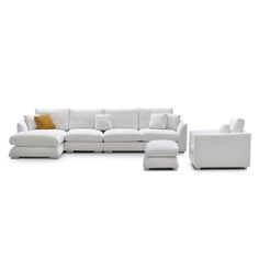 a white couch and ottoman sitting on top of a white floor next to each other