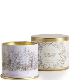 the winter white candle is in a tin with gold trimmings and an image of trees