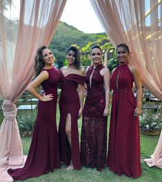 three women in long dresses standing next to each other under a canopy with pink drapes