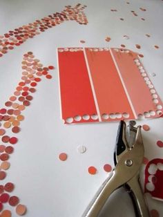 a pair of scissors sitting on top of a table next to some orange and pink paint