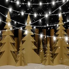 christmas lights and paper trees in front of a fence with snow falling on the ground