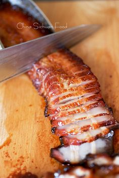 there is a large piece of meat on the cutting board with a knife next to it