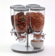 three glass containers filled with different types of food on top of a metal stand next to a white bowl