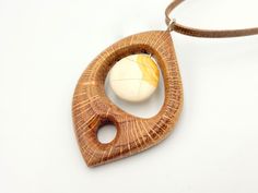 "This is a unique oak (quercus) wood necklace decorated with a beautiful pebble. The artist transformed it to a modern unique pendant totally hand carved which stands out for its natural wood colour. The artist of this pendant is Nikos Bacharidis who was born in 1946 and he is a Greek artist, sculptor, painter and engraver. Today he lives in Thessaloniki and he focuses on sculpture, abstract organic forms and nature inspired designs. Since 1971 he has participated in more than 80 group art exhib Artisan Natural Wood Pendant Necklace, Artisan Natural Wood Necklaces, Carved Necklace, Carved Jewelry, Sculpture Abstract, Wood Colour, Group Art, Organic Forms, He Lives