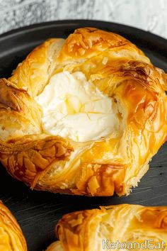 baked pastry with cream in the middle on a black plate