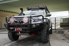 the front end of a truck parked under a bridge