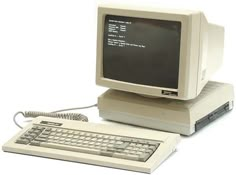 an old computer and keyboard sitting on top of each other with the screen turned off