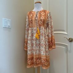 Nwt Made With Boho Dress Is A Pretty Floral Pattern Of Golds, Olive And Wine . Double Tie Front With Tassels. New With Tag . See Close Up Photos For Colors And Details Casual Yellow Boho Print Dress, Yellow V-neck Boho Dress For Spring, Orange Bohemian Knee-length Midi Dress, Yellow Bohemian Knee-length Midi Dress, Summer Long Sleeve Orange Boho Dress, Orange Long Sleeve Boho Dress For Summer, Yellow Boho Dress With Floral Print For Vacation, Orange Long Sleeve Boho Dress With Print, Yellow Mini Dress For Fall Vacation